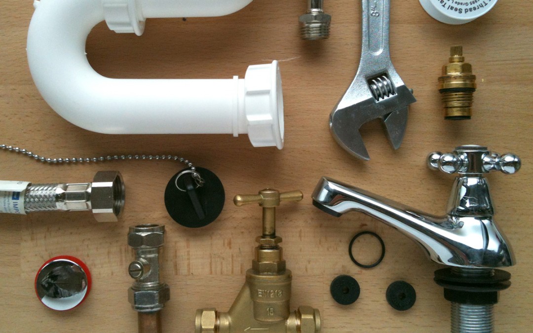 A variety of plumbing tools are laid out on a table for professional service.